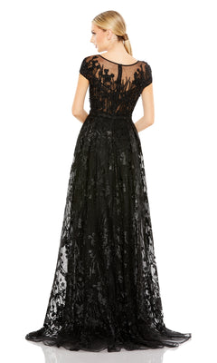 A woman is shown from the back in a Mac Duggal 20405 Short-Sleeve Long Formal Dress, featuring embroidered lace and floral details, set against a white background.