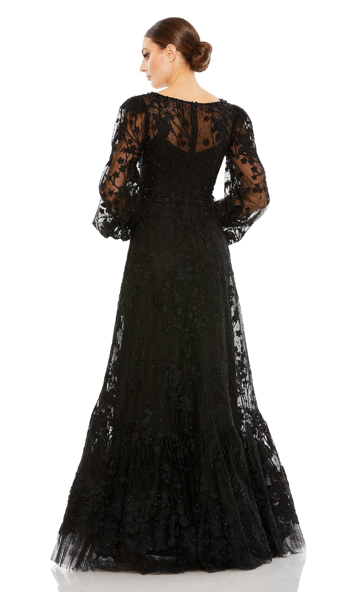 A woman stands with her back to the camera against a white background, wearing the Mac Duggal 20430 long sleeve formal dress—an elegant black evening gown with embroidery and sheer long sleeves.