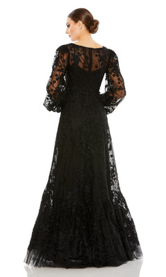 A woman stands with her back to the camera against a white background, wearing the Mac Duggal 20430 long sleeve formal dress—an elegant black evening gown with embroidery and sheer long sleeves.