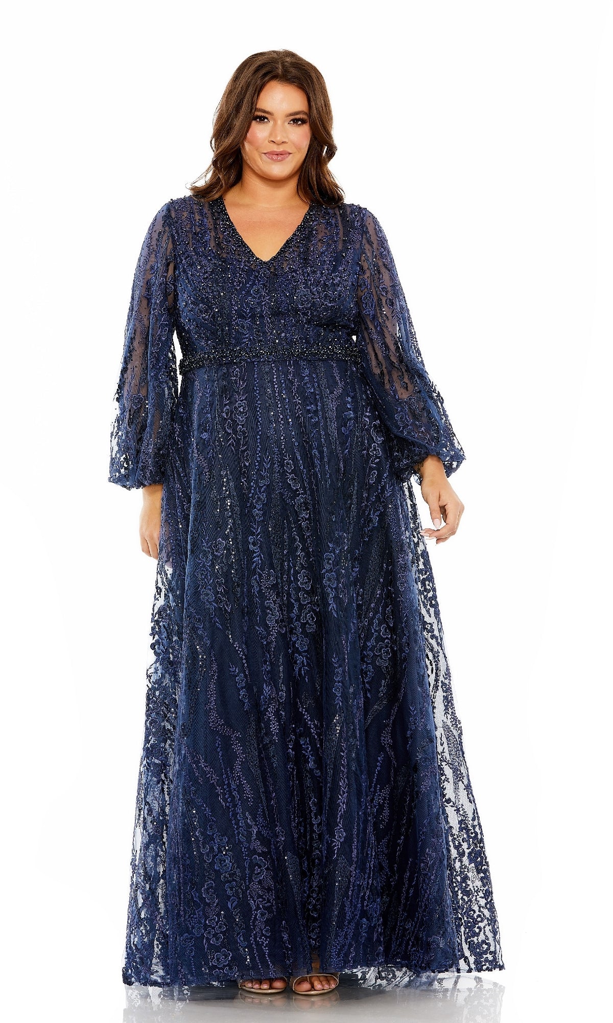 A woman is wearing the Long Plus-Size Formal Dress: Mac Duggal 20472 in midnight—a formal evening gown featuring a long, plus-size silhouette with a v-neckline, sheer sleeves, and delicate floral embroidery. She stands facing forward against a white background.