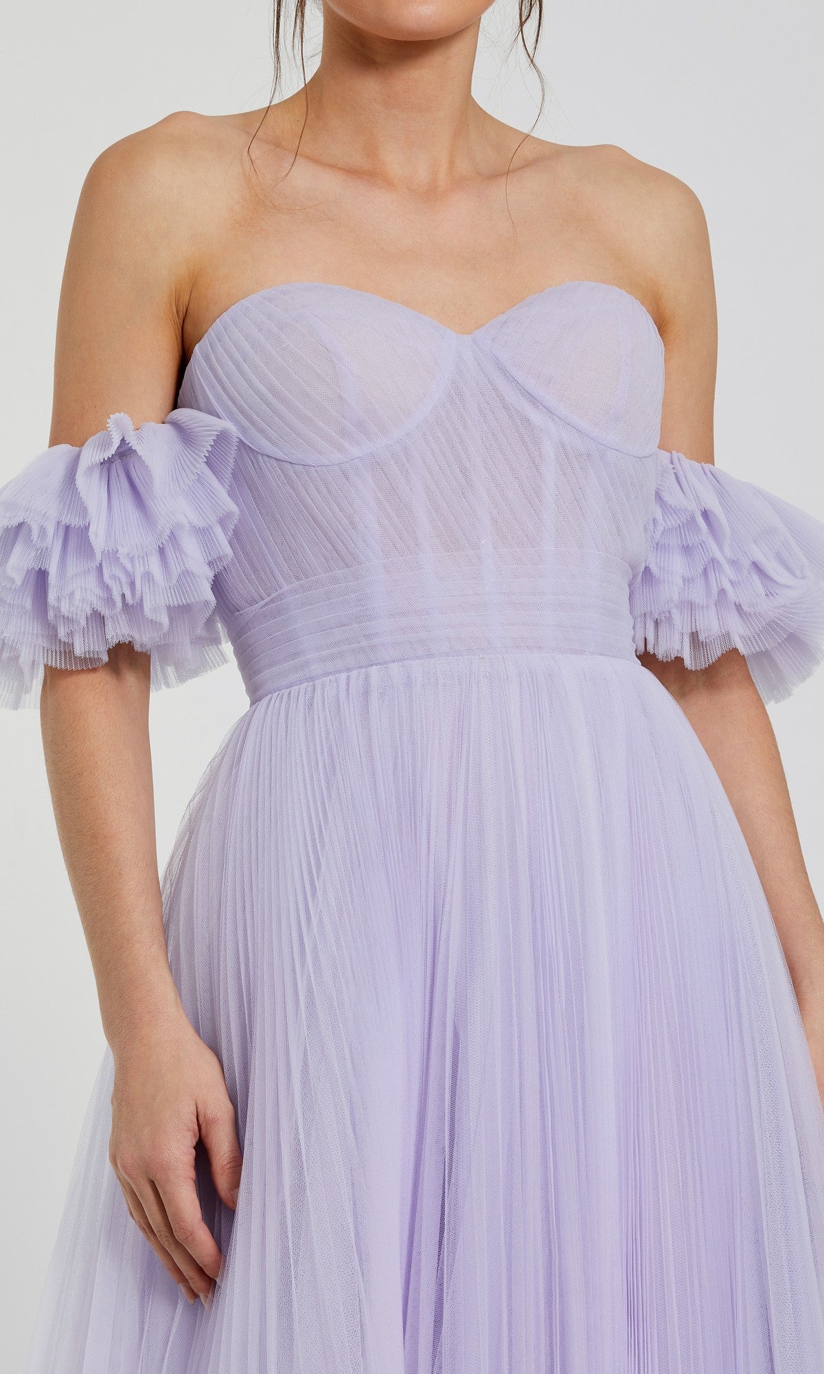 Woman wears the Mac Duggal 20517 long formal dress, a strapless lilac gown with pleated tulle and ruffled off-shoulder sleeves—an elegant choice for any formal occasion.