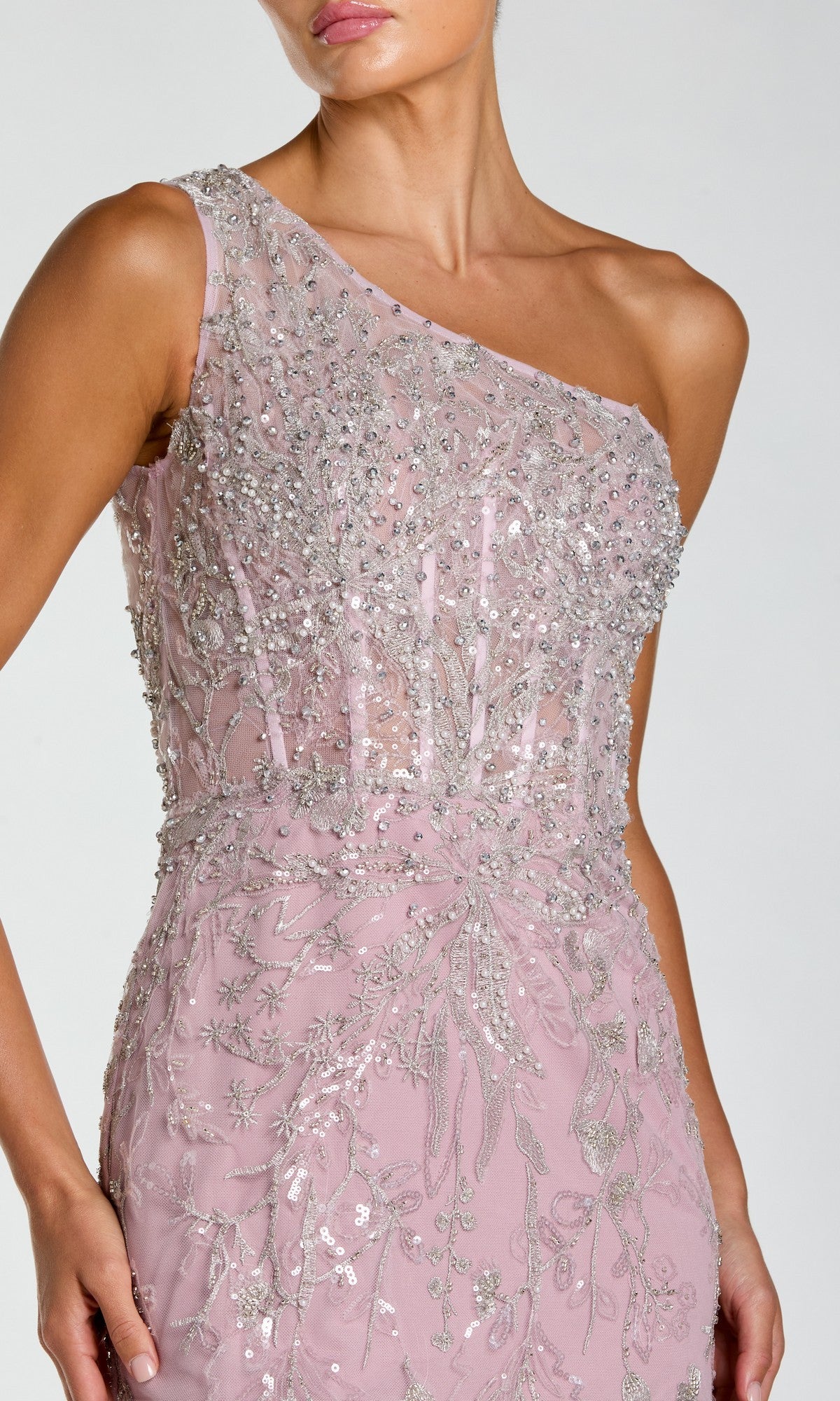 A woman in the Mac Duggal 20543 long formal dress—a light pink, one-shoulder gown with silver sequin and embroidered accents—shown from shoulders to mid-thigh.