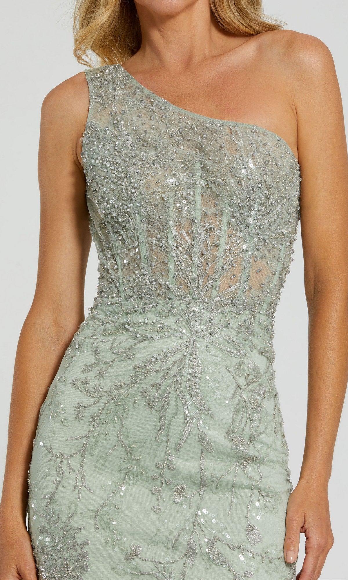 Person wearing the Mac Duggal 20543 long formal dress—a light green, one-shoulder gown with sequins and intricate beadwork embellishing its sheer bodice.