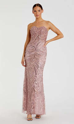 A woman models the Mac Duggal 20544 strapless long beaded prom dress in blush pink with intricate sequin details, standing against a plain white background.