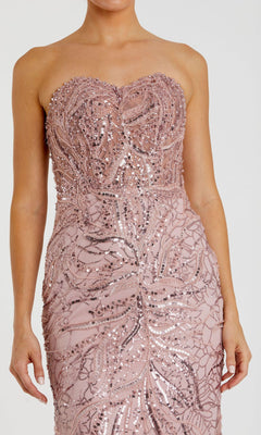 Someone wearing the Mac Duggal 20544 Strapless Long Beaded Prom Dress—a fitted, light pink gown featuring intricate sequin and bead embellishments.