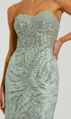 Wearing the Mac Duggal 20544, a strapless long beaded prom dress in light green with intricate silver sequin and bead details, exudes true evening gown elegance.
