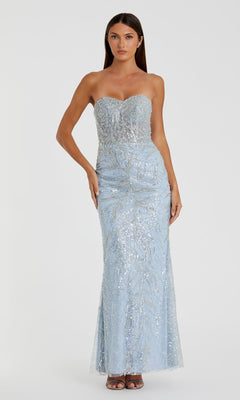 A woman models the Mac Duggal 20544 Strapless Long Beaded Prom Dress in light blue with silver sequins, standing before a plain white background.
