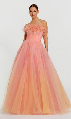 A woman stands against a plain light background wearing the Mac Duggal Long Formal Dress 20557, featuring an ombre feather design, strapless bodice, and full tulle skirt.