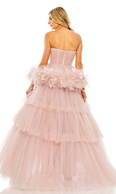 A woman faces away in the Long Formal Dress 20572 by Mac Duggal, featuring a strapless sweetheart bodice, layered blush pink tulle, and feathered ruffled accents for an elegant silhouette.