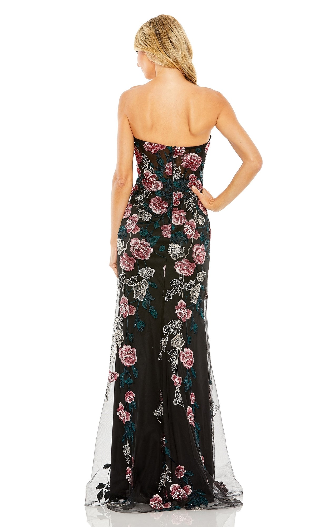 A woman with blonde hair is shown from the back wearing the Long Formal Dress 20581 by Mac Duggal, a strapless gown with pink and green floral embroidery.