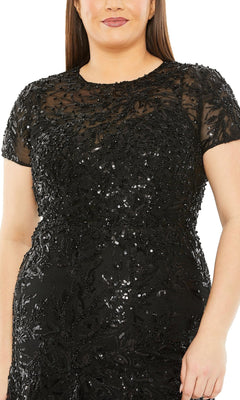 Wearing the Long Plus-Size Prom Dress 20623 by Mac Duggal, a black high-neck dress with short sleeves, sequin and bead embellishments, and a sheer overlay on the upper bodice.