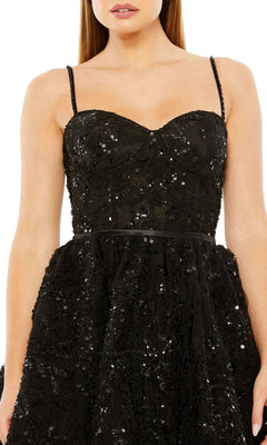 A woman wears the Short Black Beaded Hoco Dress: Mac Duggal 20641, featuring thin straps, a fitted bodice, and sparkling sequins—a stunning cocktail dress perfect for any occasion.