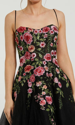 Woman in the Mac Duggal 20651 Floral Embroidered A-Line Midi Dress—a sleeveless black dress with thin straps and red and pink floral embroidery, ideal as a party or wedding guest dress.