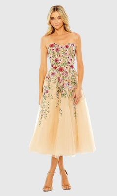A woman smiles with her hands by her sides in the Mac Duggal 20651 Floral Embroidered A-Line Midi Dress—an elegant sleeveless beige tulle option, perfect for a wedding guest.