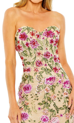 A woman wears the Mac Duggal 20652, a strapless long formal dress featuring a nude base with detailed pink, red, and green floral embroidery.