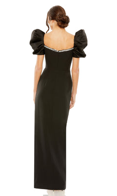 A woman with her hair in a low bun faces away from the camera, wearing the Long Formal Dress 20687 by Mac Duggal— a fitted black gown featuring puffed short sleeves and a decorative trim on the sweetheart neckline.