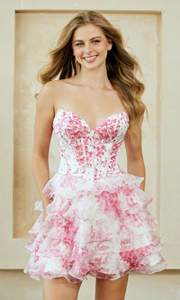 Woman wearing a short strapless pink and white floral dress against a neutral background