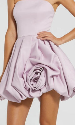 A woman wears the Red Rose Bubble-Hem Hoco Dress (Mac Duggal 20705), a strapless mini dress featuring sculpted rose-like details and a satin bubble skirt, perfect for cocktails.