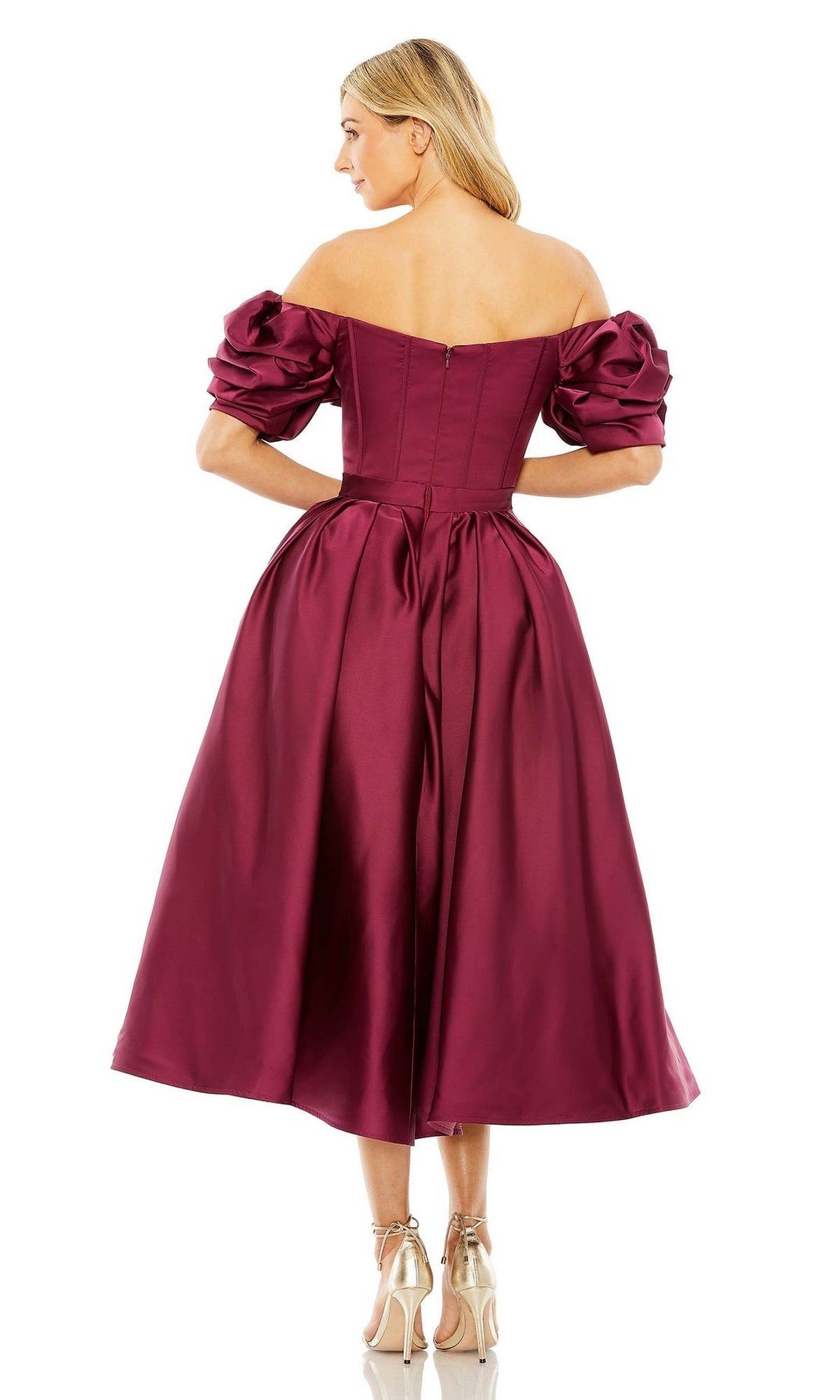 A woman is seen from the back in the Mac Duggal 20706, an off-shoulder midi wedding guest dress in burgundy satin with puffed sleeves and fitted bodice, styled with strappy high heels for a chic semi-formal look.