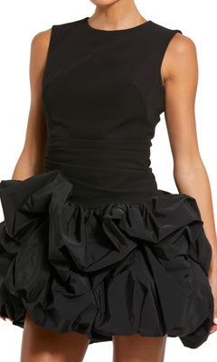 A woman wears the Short Black Bubble Party Dress, Mac Duggal 20709—a chic sleeveless cocktail dress with a fitted bodice and ruffled mini bubble skirt, perfect for any special evening.