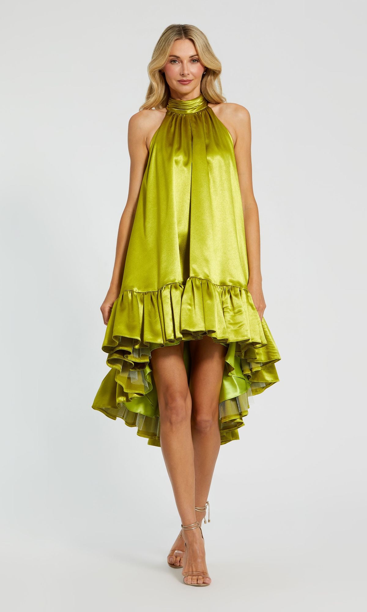 A woman stands against a white background wearing the Mac Duggal 20711 Satin Wedding Guest Dress, featuring a shiny lime green color, high neck, and ruffled high-low hemline.