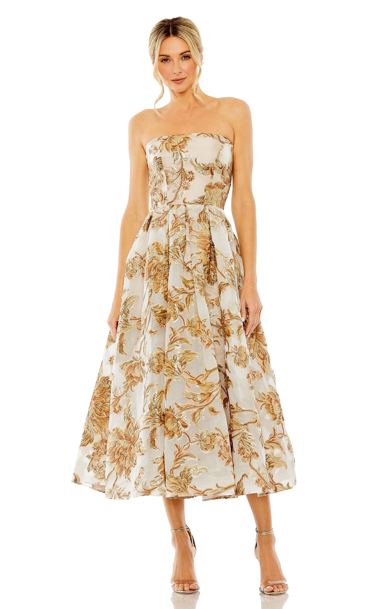 A woman wears the Strapless Bronze Party Dress: Mac Duggal 20716, featuring a beige and gold floral pattern, paired with neutral heels against a white background.