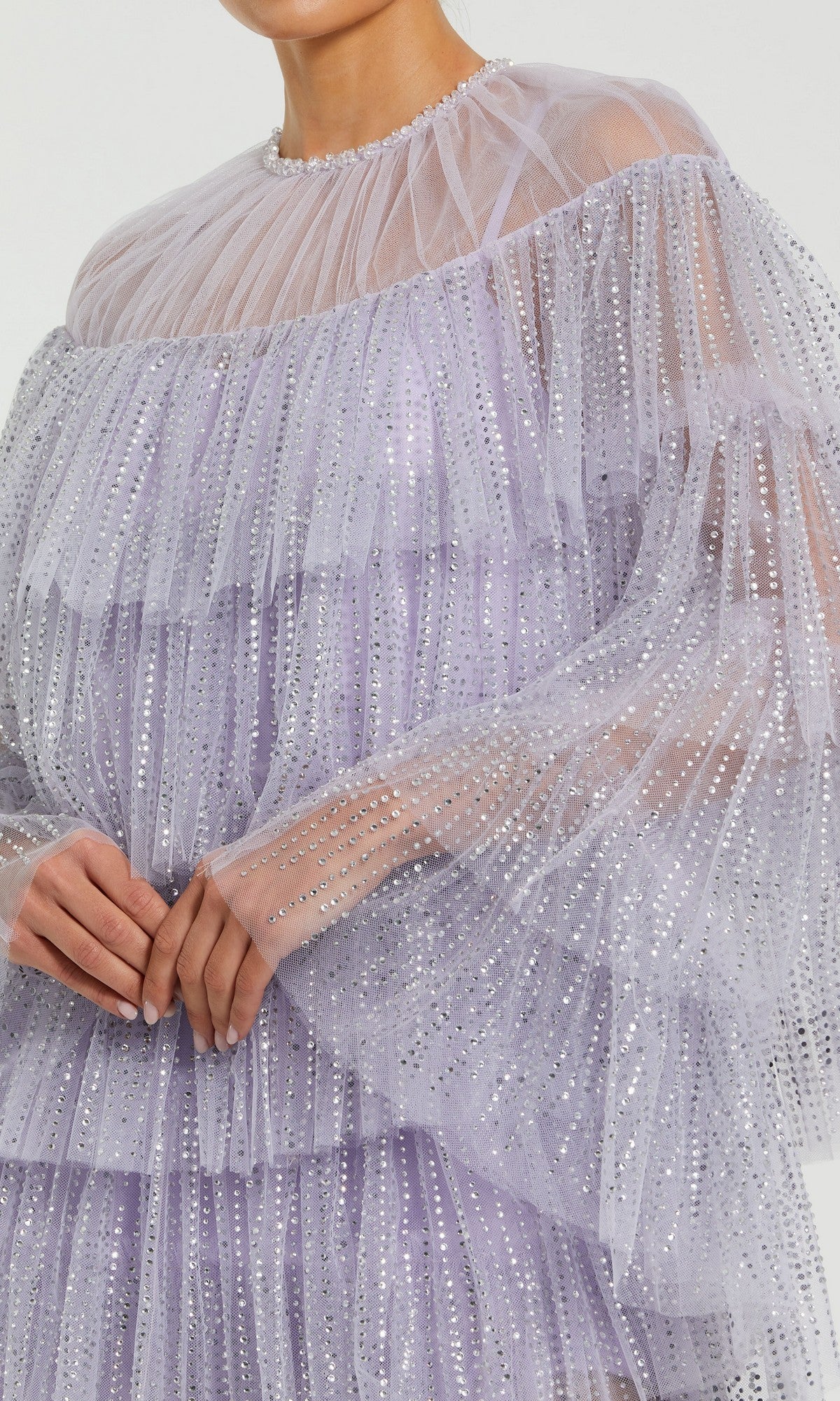 A person in a sheer lavender Mac Duggal 20749 short party dress with a high-neck ruffle and silver sequins, showing only their lower face and upper torso.