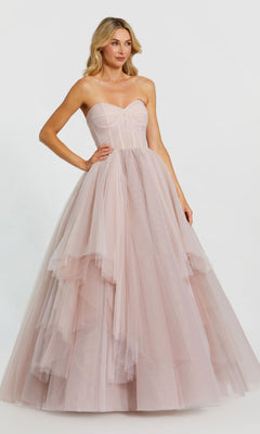 A woman models the Long Formal Dress 20772 by Mac Duggal, featuring a strapless ruched bodice and layered tulle ball gown skirt in light pink, standing against a plain white background.