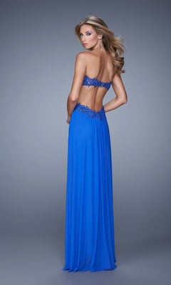 A woman models the Strapless Cut-Out La Femme Jersey Prom Dress 20826 in royal blue, featuring an open back and beaded lace details, while standing and looking over her shoulder against a plain gray background.