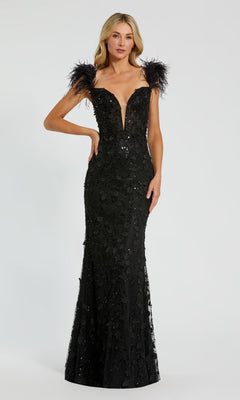A woman showcases the Long Formal Dress 20889 by Mac Duggal, featuring a fitted, floor-length black silhouette with a sweetheart v-neckline, sequin details, and bold feather straps against a plain background.