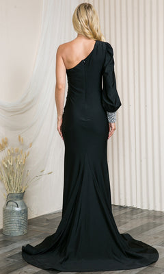 A woman stands indoors facing away, wearing the Embellished-Cuff One-Sleeve Long Prom Dress 2102—a black evening gown with a single long sleeve and silver cuff detail.
