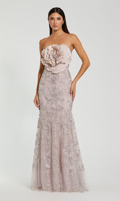 A woman in the Mac Duggal 21036 Strapless Long Floral Prom Dress, light pink with a floral applique bodice and lace details, exudes timeless elegance in this vintage-inspired formal gown.