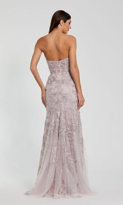 A woman is shown from the back wearing the Mac Duggal 21036 Strapless Long Floral Prom Dress in mocha pink, with delicate lace and sequin details, set against a simple light background.