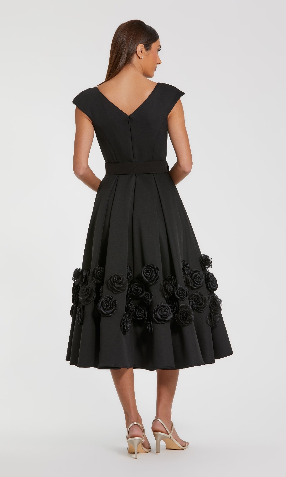 Black dress with 3D floral details on the a-line skirt, standing in front of a white background