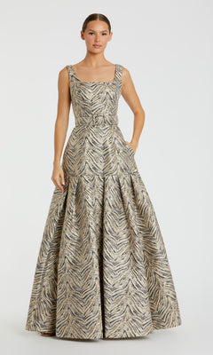 A woman wears the Mac Duggal 21054 Gold Zebra-Print Long Prom Gown—a sleeveless, floor-length dress with a fitted bodice and flared skirt.