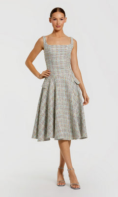 A woman wears the Mac Duggal 21066 Midi Party Dress in Pastel Multi, featuring a sleeveless fitted bodice, square neckline, and knee-length flared skirt, paired with silver strappy heels.