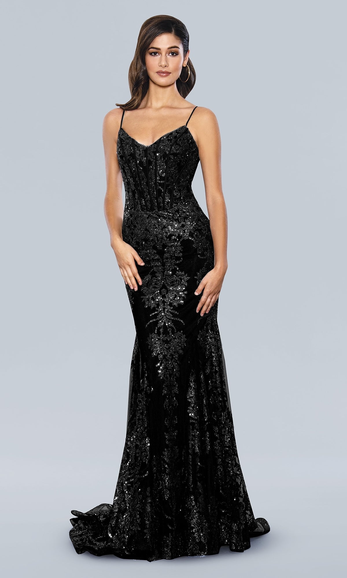 A woman wears the Corset-Bodice Sparkly Long Mermaid Prom Dress 21066—a fitted, floor-length black sequin gown with thin straps—standing against a plain light gray background.