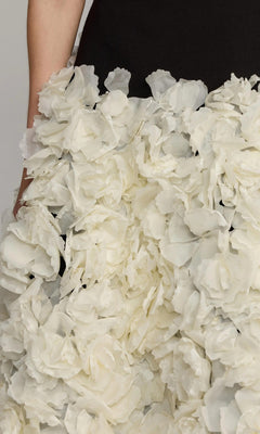 Close-up of the Mac Duggal 21080 Midi Wedding Guest Dress, showcasing a black top and a skirt embellished with countless white, textured three-dimensional organza flowers.