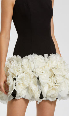 Black dress with white floral skirt on a plain background