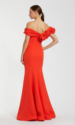 Wearing the Off-Shoulder Long Formal Dress: Mac Duggal 21104—a bright red gown with a fitted bodice and large fabric rosettes on the back—a person stands against a plain background.