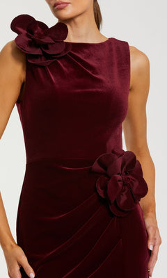 Close-up of the bodice of a burgundy evening gown featuring two large 3D flower details with a white background.