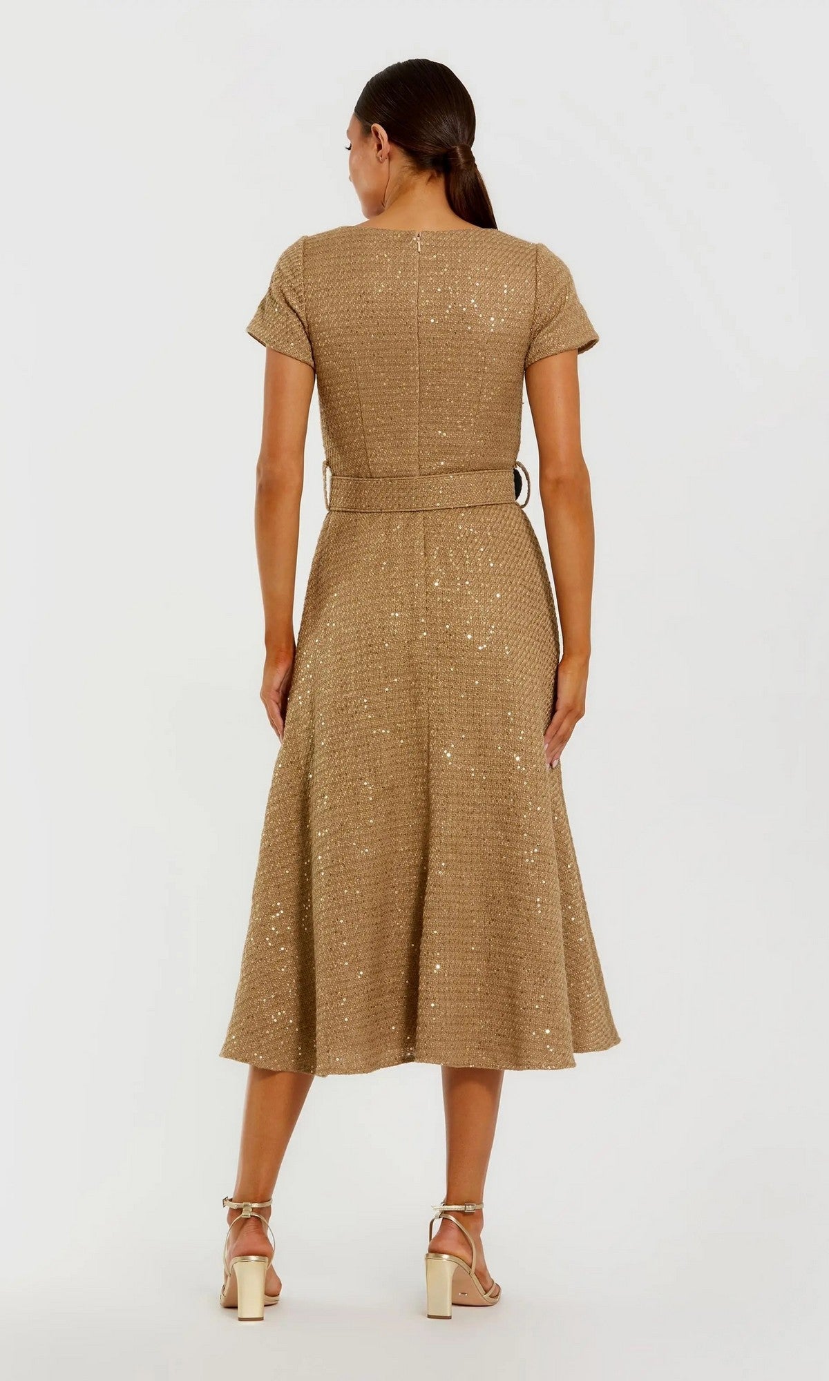 A woman, seen from behind, wears the Midi Wedding Guest Dress: Mac Duggal 21166 featuring short sleeves, a belted waist, sequins, and a flared skirt, elegantly styled with strappy heeled sandals.