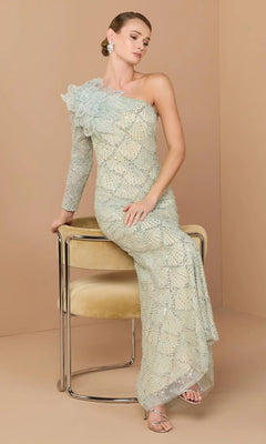 A woman in a seafoam Mac Duggal 21203 long formal one-shoulder gown with beading and floral appliqué sits on a beige chair against a plain tan background.