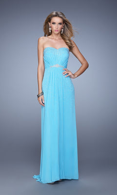 A woman models the La Femme Embellished-Jersey Prom Dress 21237, a strapless, floor-length light blue gown with subtle embellishments, standing against a simple gradient backdrop.