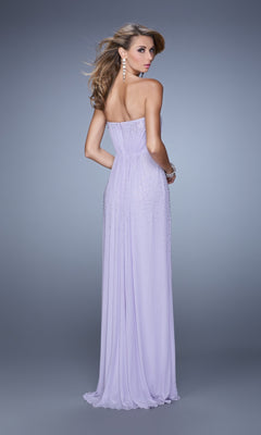 A woman stands with her back to the camera against a gray background, wearing the La Femme Embellished-Jersey Prom Dress 21237, a strapless floor-length lavender gown adorned with beaded details.