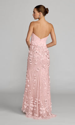 A woman wearing the Mac Duggal 21261 long formal dress, featuring a strapless sweetheart neckline and delicate 3D flower embellishments on satin, stands against a plain background with her back to the camera.