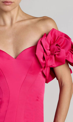 A woman wearing the Mac Duggal 21263 Long Formal Dress in hot-pink satin, showcasing an off-the-shoulder silhouette with a dramatic, sculpted floral sleeve detail—an exquisite choice for any elegant occasion.