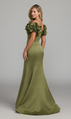 A woman wearing the Mac Duggal 21263 long formal dress in olive green satin, featuring an off-the-shoulder design and large floral embellishments on the sleeves, stands against a plain gray background.