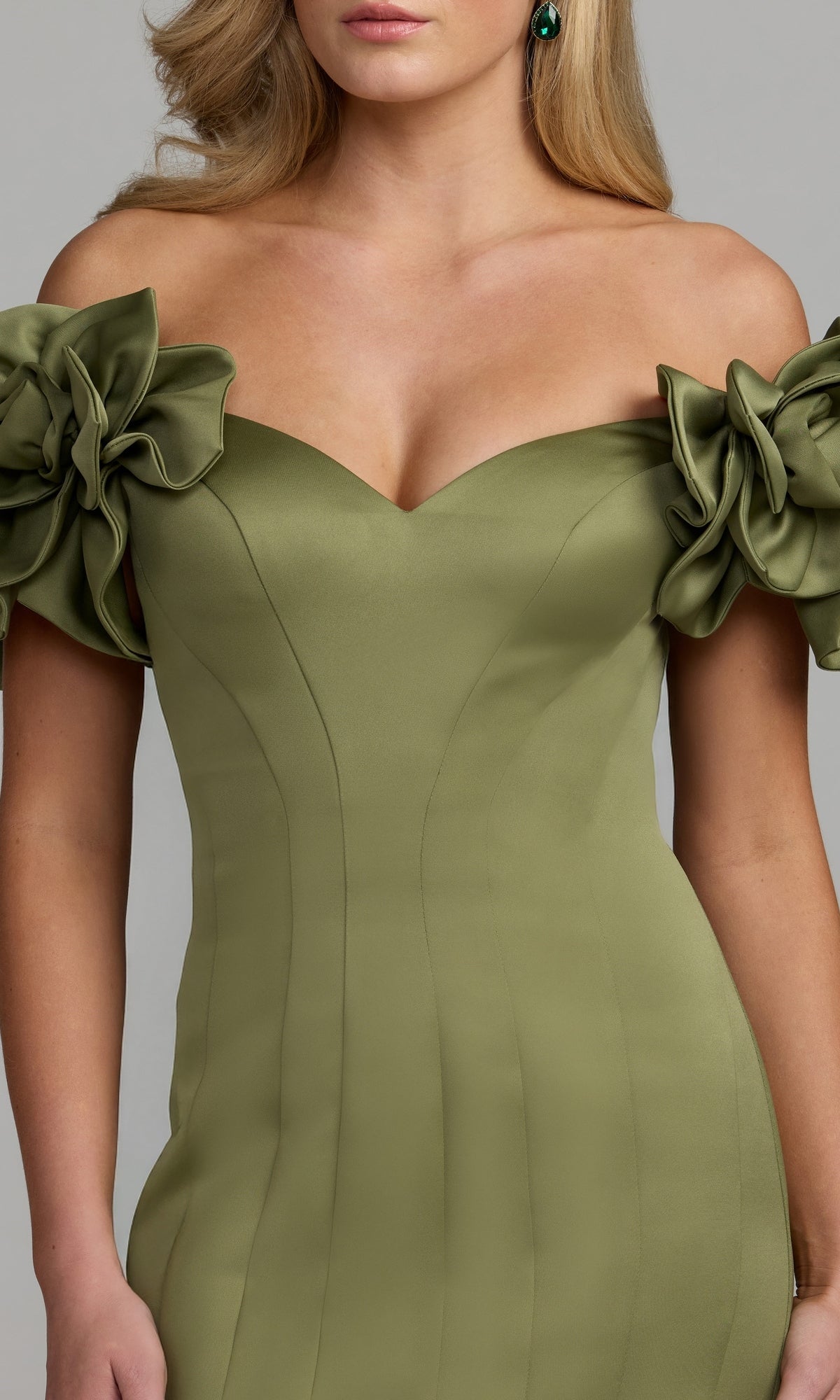 A woman wearing the upper portion of the Mac Duggal 21263 Long Formal Dress in olive green satin, featuring an off-the-shoulder design and large floral sleeve details.
