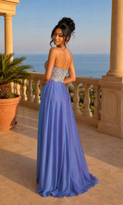 A woman wears the La Femme Embroidered Chiffon Prom Dress 21289, standing on a stone balcony with ornate railings and gazing at the sea during sunset.